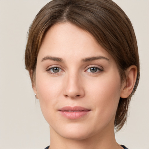 Joyful white young-adult female with medium  brown hair and grey eyes