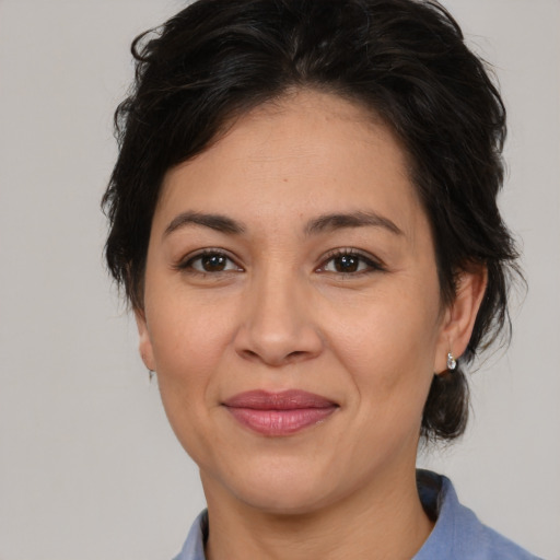 Joyful latino adult female with medium  brown hair and brown eyes