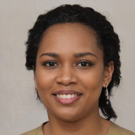 Joyful black young-adult female with medium  brown hair and brown eyes