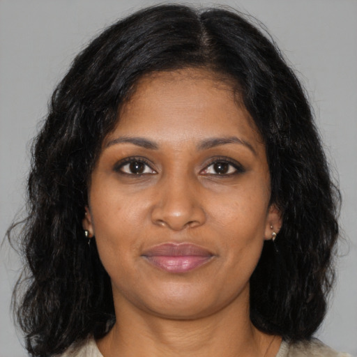 Joyful black young-adult female with medium  brown hair and brown eyes