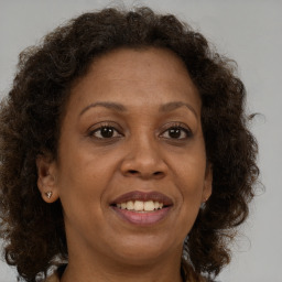 Joyful black adult female with medium  brown hair and brown eyes