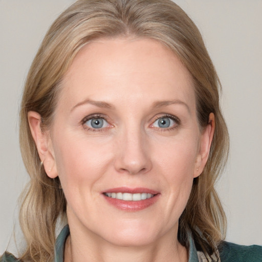 Joyful white adult female with medium  brown hair and blue eyes