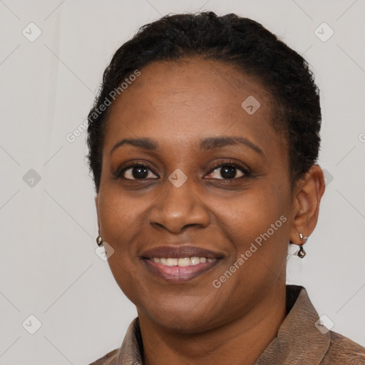 Joyful black adult female with short  black hair and brown eyes