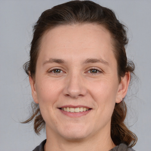 Joyful white adult female with medium  brown hair and brown eyes