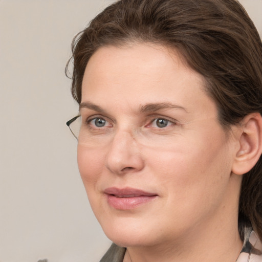 Joyful white adult female with medium  brown hair and grey eyes