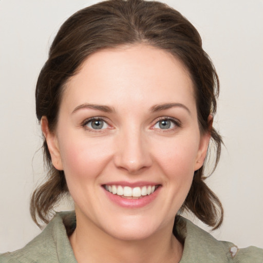 Joyful white young-adult female with medium  brown hair and green eyes