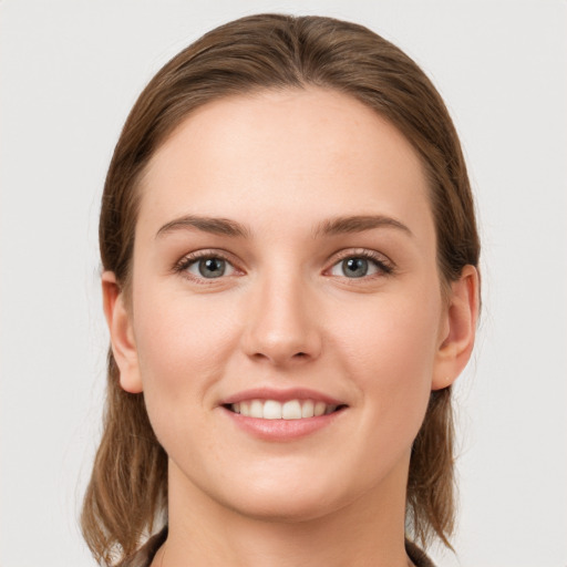 Joyful white young-adult female with medium  brown hair and grey eyes