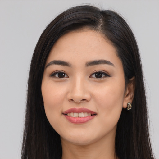 Joyful latino young-adult female with long  black hair and brown eyes