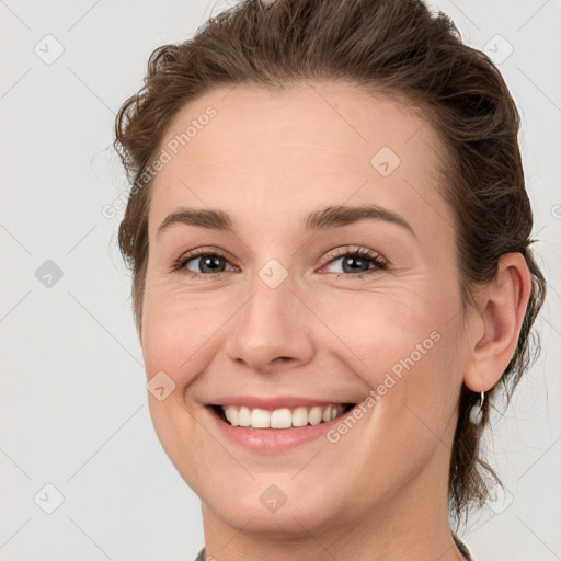 Joyful white young-adult female with medium  brown hair and grey eyes