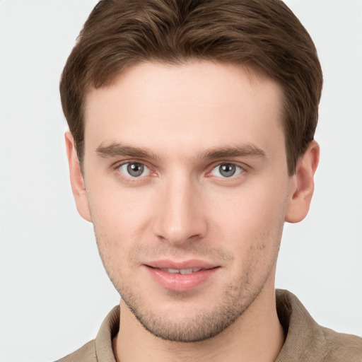 Joyful white young-adult male with short  brown hair and grey eyes