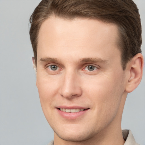 Joyful white young-adult male with short  brown hair and grey eyes