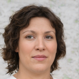 Joyful white young-adult female with medium  brown hair and green eyes