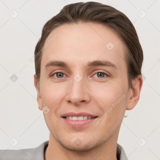 Joyful white young-adult male with short  brown hair and grey eyes