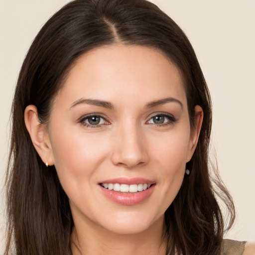 Joyful white young-adult female with long  brown hair and brown eyes