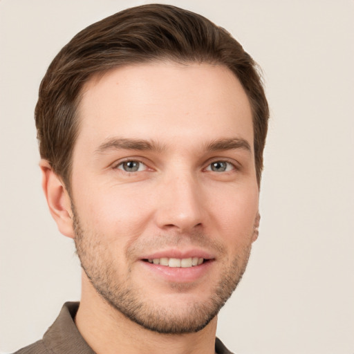 Joyful white young-adult male with short  brown hair and grey eyes