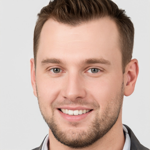 Joyful white young-adult male with short  brown hair and grey eyes