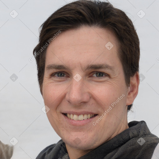 Joyful white adult male with short  brown hair and grey eyes