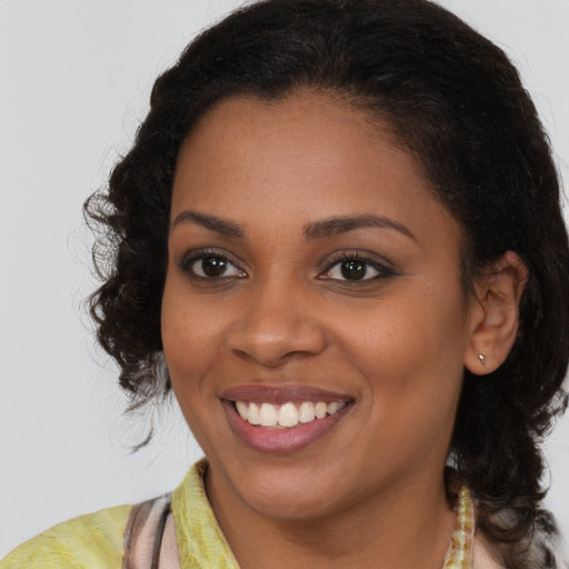 Joyful black young-adult female with long  brown hair and brown eyes