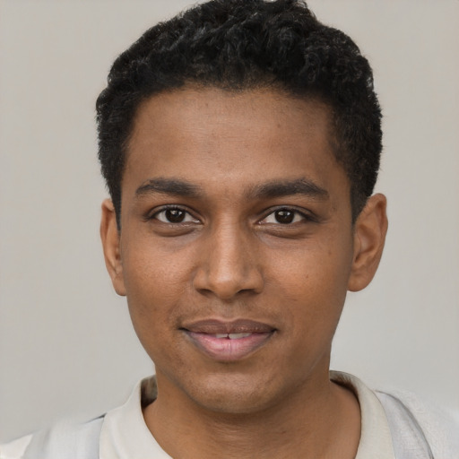 Joyful black young-adult male with short  black hair and brown eyes