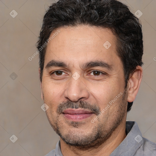 Joyful white adult male with short  black hair and brown eyes