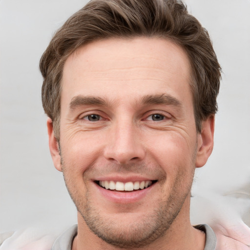 Joyful white young-adult male with short  brown hair and grey eyes