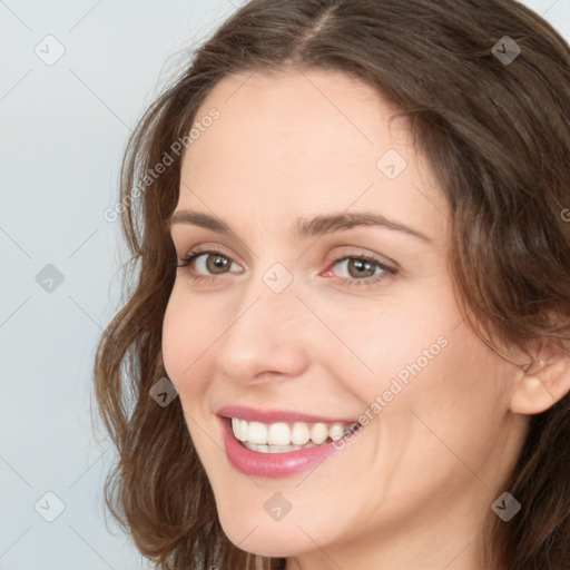 Joyful white young-adult female with long  brown hair and green eyes