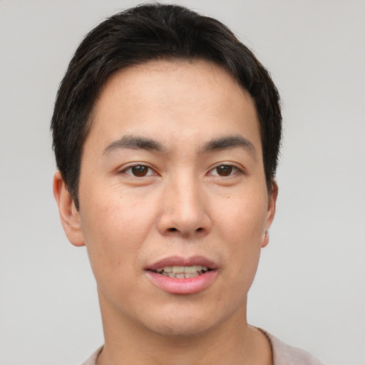 Joyful asian young-adult male with short  brown hair and brown eyes