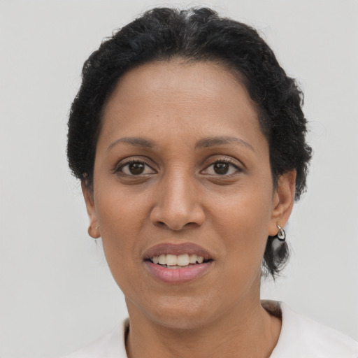 Joyful latino adult female with short  black hair and brown eyes