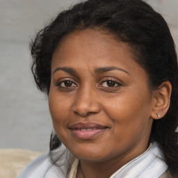 Joyful black adult female with medium  brown hair and brown eyes