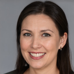 Joyful white adult female with long  brown hair and brown eyes