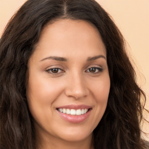 Joyful white young-adult female with long  brown hair and brown eyes