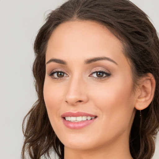 Joyful white young-adult female with long  brown hair and brown eyes