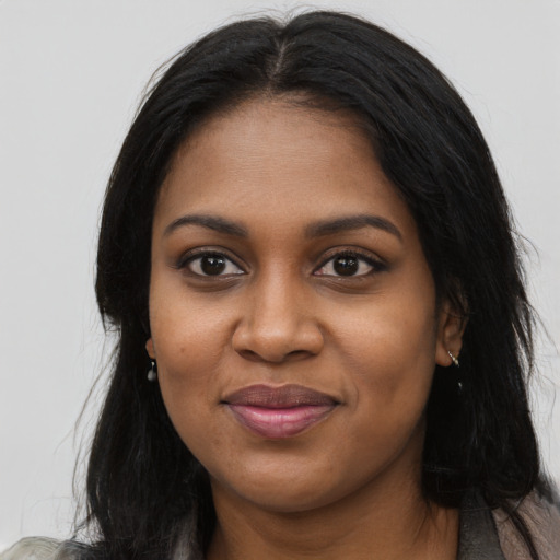 Joyful black young-adult female with long  black hair and brown eyes