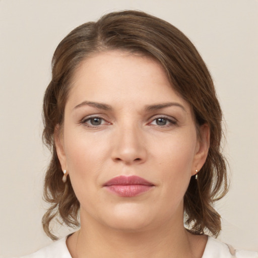 Joyful white young-adult female with medium  brown hair and grey eyes