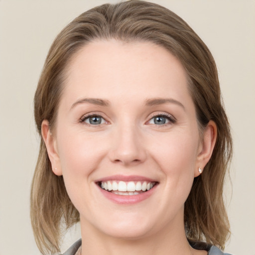 Joyful white young-adult female with medium  brown hair and grey eyes