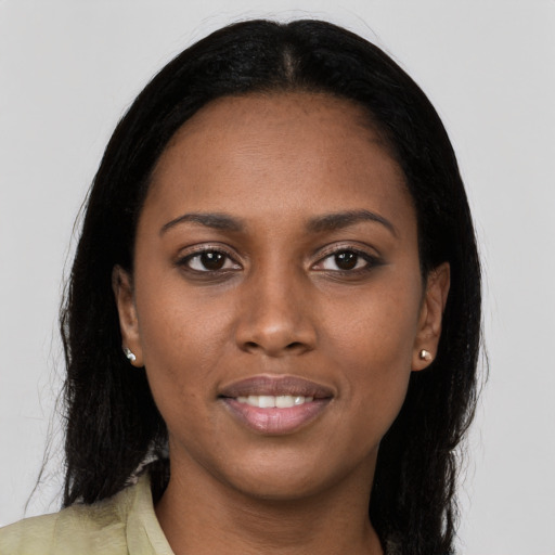Joyful black young-adult female with long  brown hair and brown eyes