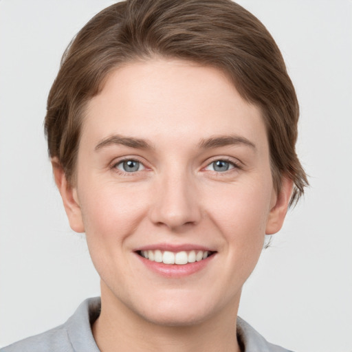 Joyful white young-adult female with short  brown hair and grey eyes