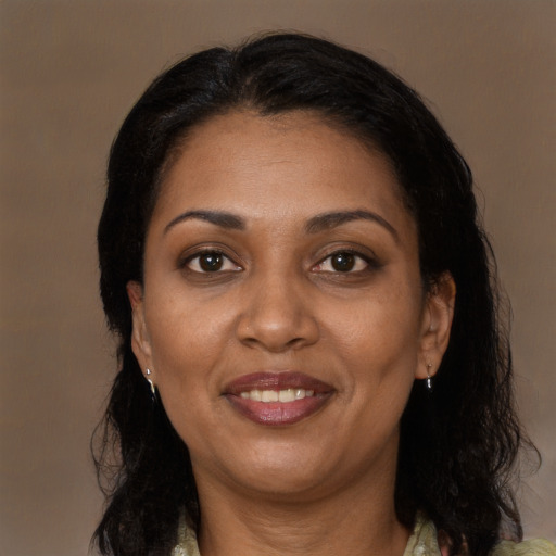Joyful black adult female with long  brown hair and brown eyes