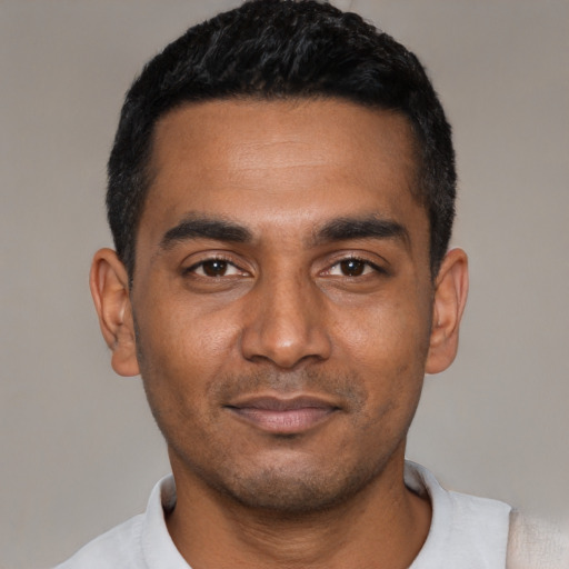 Joyful black young-adult male with short  black hair and brown eyes