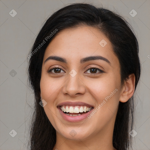 Joyful latino young-adult female with long  brown hair and brown eyes