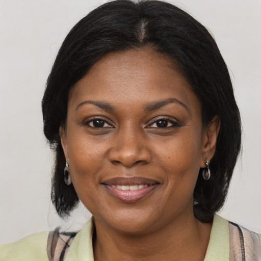 Joyful black adult female with medium  brown hair and brown eyes