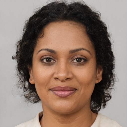 Joyful black adult female with medium  brown hair and brown eyes