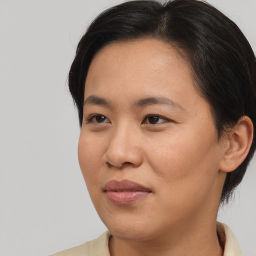 Joyful asian young-adult female with short  brown hair and brown eyes
