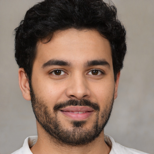 Joyful latino young-adult male with short  black hair and brown eyes