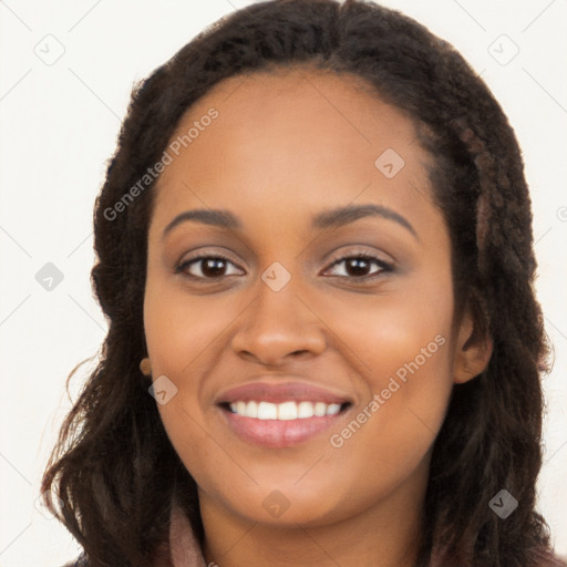 Joyful black young-adult female with long  brown hair and brown eyes