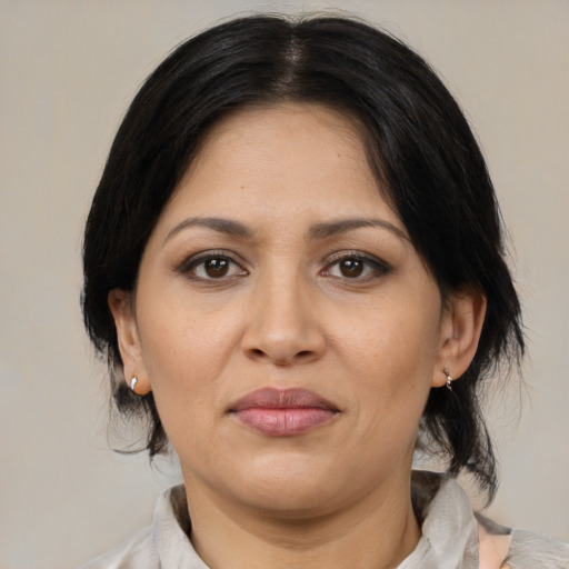Joyful latino adult female with medium  brown hair and brown eyes