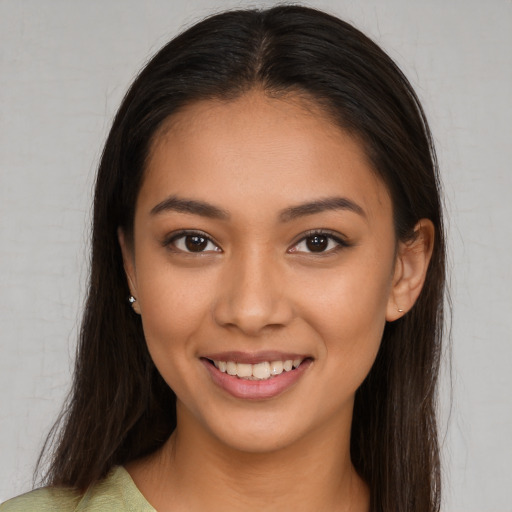 Joyful latino young-adult female with long  brown hair and brown eyes