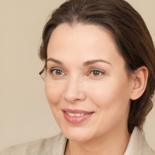 Joyful white adult female with medium  brown hair and brown eyes