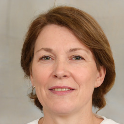 Joyful white adult female with medium  brown hair and green eyes