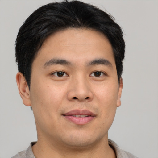 Joyful asian young-adult male with short  brown hair and brown eyes